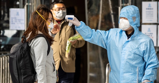 Personal de prevención toma la temperatura a una ciudadana en las calles de Guangzhou, China. EFE/EPA/ALEX PLAVEVSKI