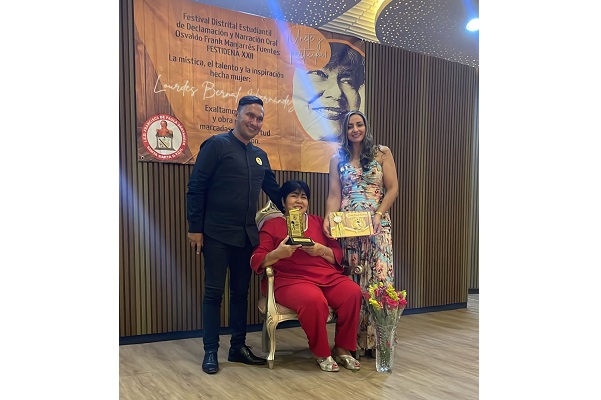 El rector de la Institución Educativa Distrital, ‘Francisco de Paula Santander’, Acompañado de la docente, Katia Escorcia, directora del Área de Lengua Castellana, cuando entregaban los reconocimientos a la docente Lourdes Bernal, por su entrega y dedicación al plantel educativo, y su apoyo incondicional al buen uso de la lengua castellana a través de su magnífica obra literaria de versos y poemas.