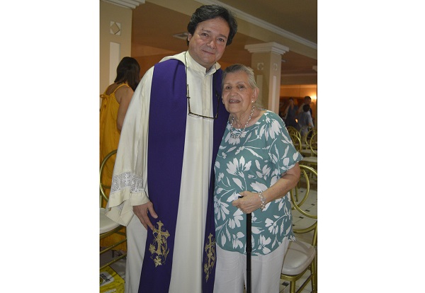 La cumpleañera Toñita Caballero de Pacheco y el padre Miguel Ángel Arévalo.