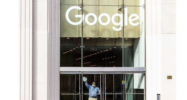 Un empleado limpia uno de los cristales de las oficinas de Google en Nueva York, empresa que fue fundada hace 25 años. (Foto EFE/EPA/Justin Lane)