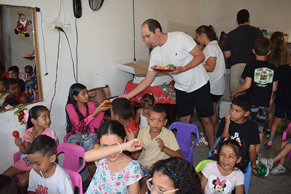 Nicolás Sánchez, entregando los desayunos navideños a los niños del barrio Los Fundadores.