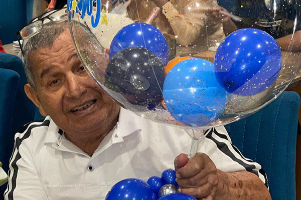 Miguel Navas Castro disfrutando su agasajo con globos y una sonrisa distintiva que refleja la felicidad del momento. Miguel Navas Castro disfrutando su agasajo con globos y una sonrisa distintiva que refleja la felicidad del momento.
