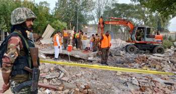 Los equipos de rescate buscan víctimas entre los escombros en el lugar de un atentado suicida en una mezquita durante las oraciones en Pakistán.